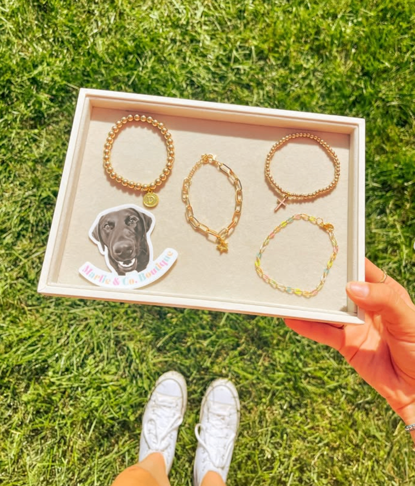Gold bracelet stack with a Marlie sticker